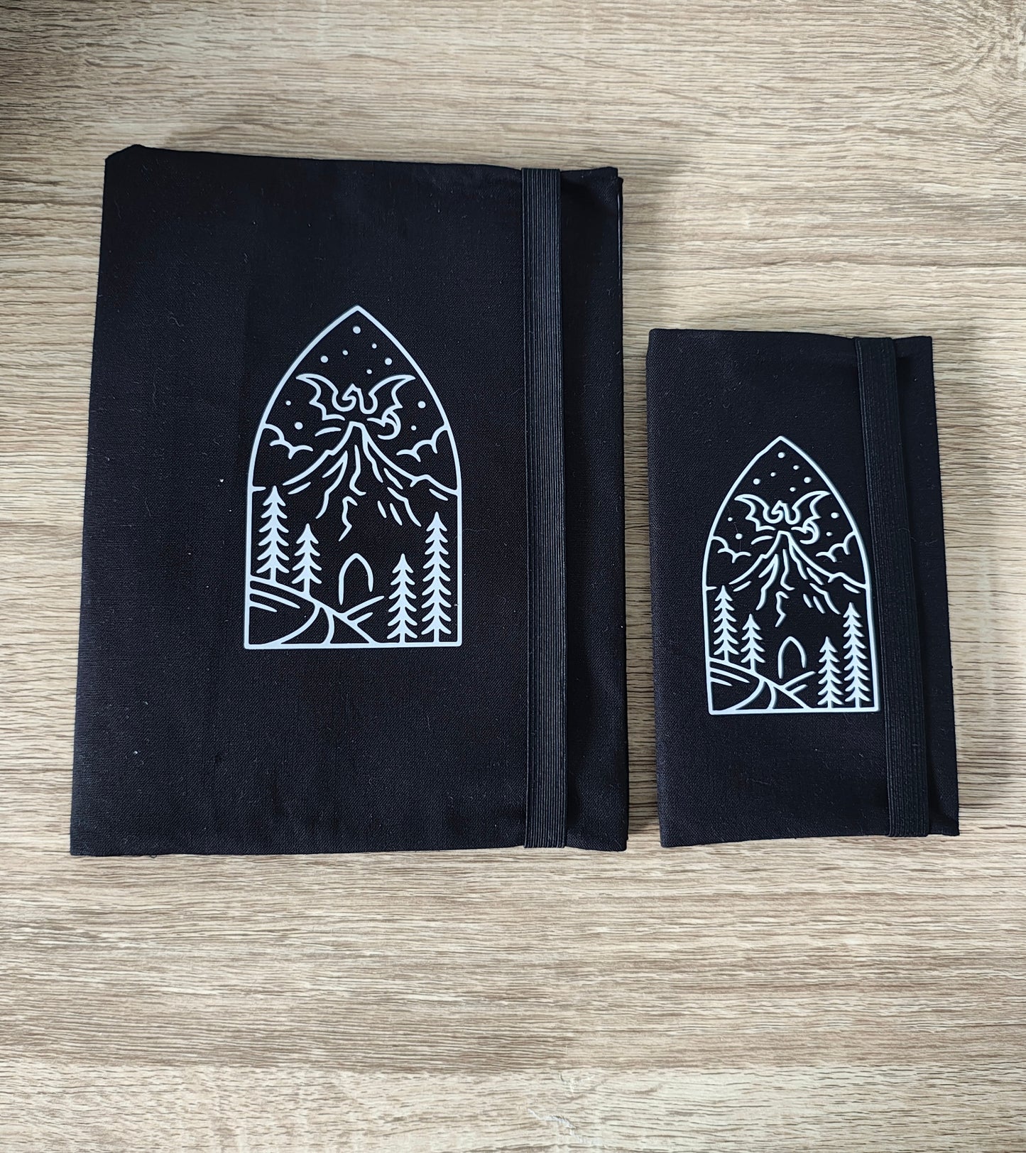 Black fabric dragon mountain note book covers on a wooden surface