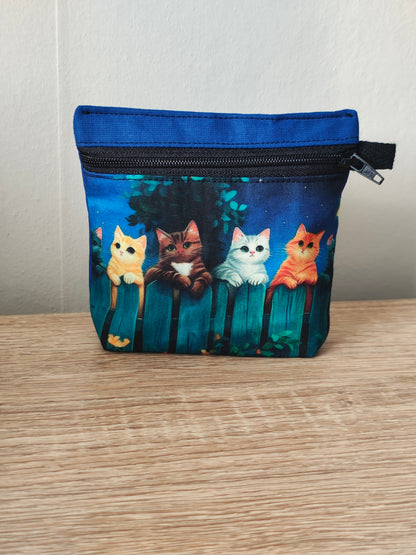 Small pouch with cat illustrations on a wooden surface