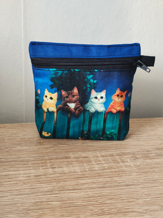 Small pouch with cat illustrations on a wooden surface