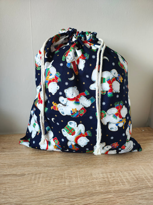 Festive fabric bag with snow bears design on a wooden surface