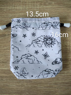Drawstring bag with celestial pattern on a wooden surface, showing measurements.