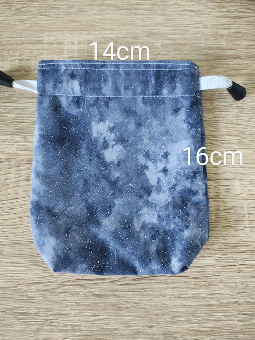 Grey drawstring bag with measurements on a wooden surface
