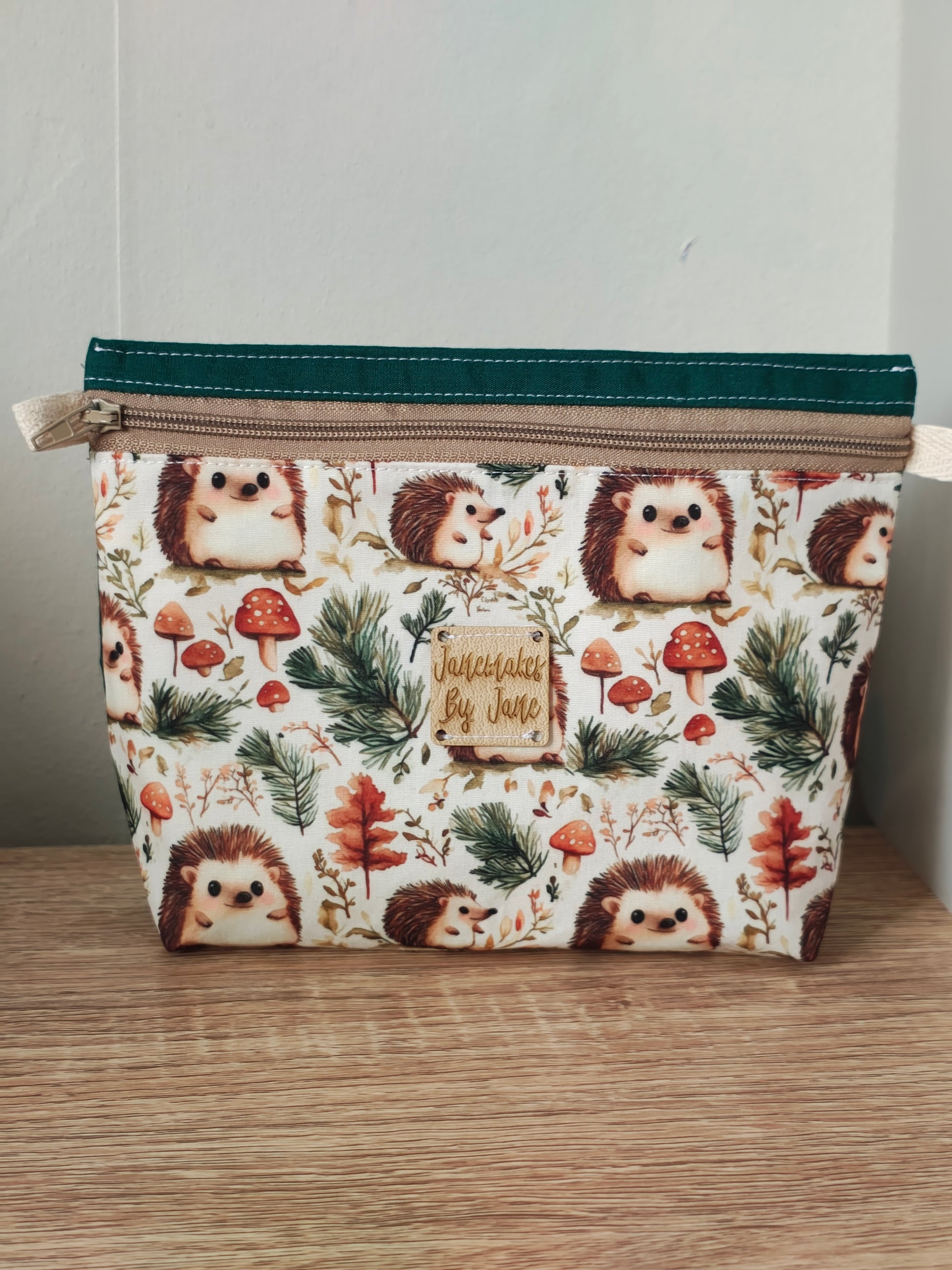 Fabric pouch with hedgehog pattern on a wooden surface