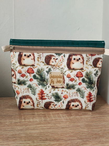 Fabric pouch with hedgehog pattern on a wooden surface