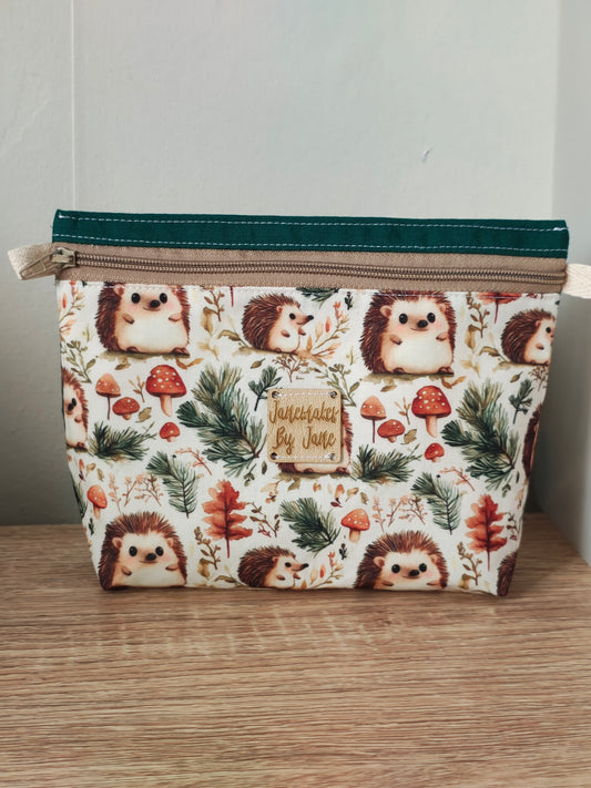 Fabric pouch with hedgehog pattern on a wooden surface