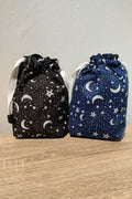 Two drawstring bags with star and moon patterns on a wooden surface.